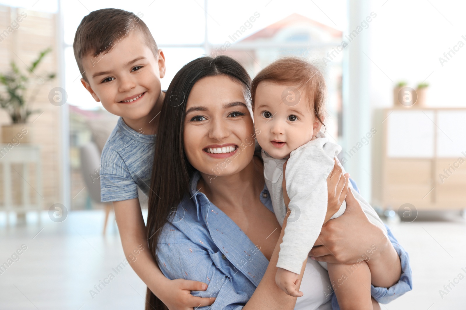 Photo of Happy mother with her cute children at home. Family time