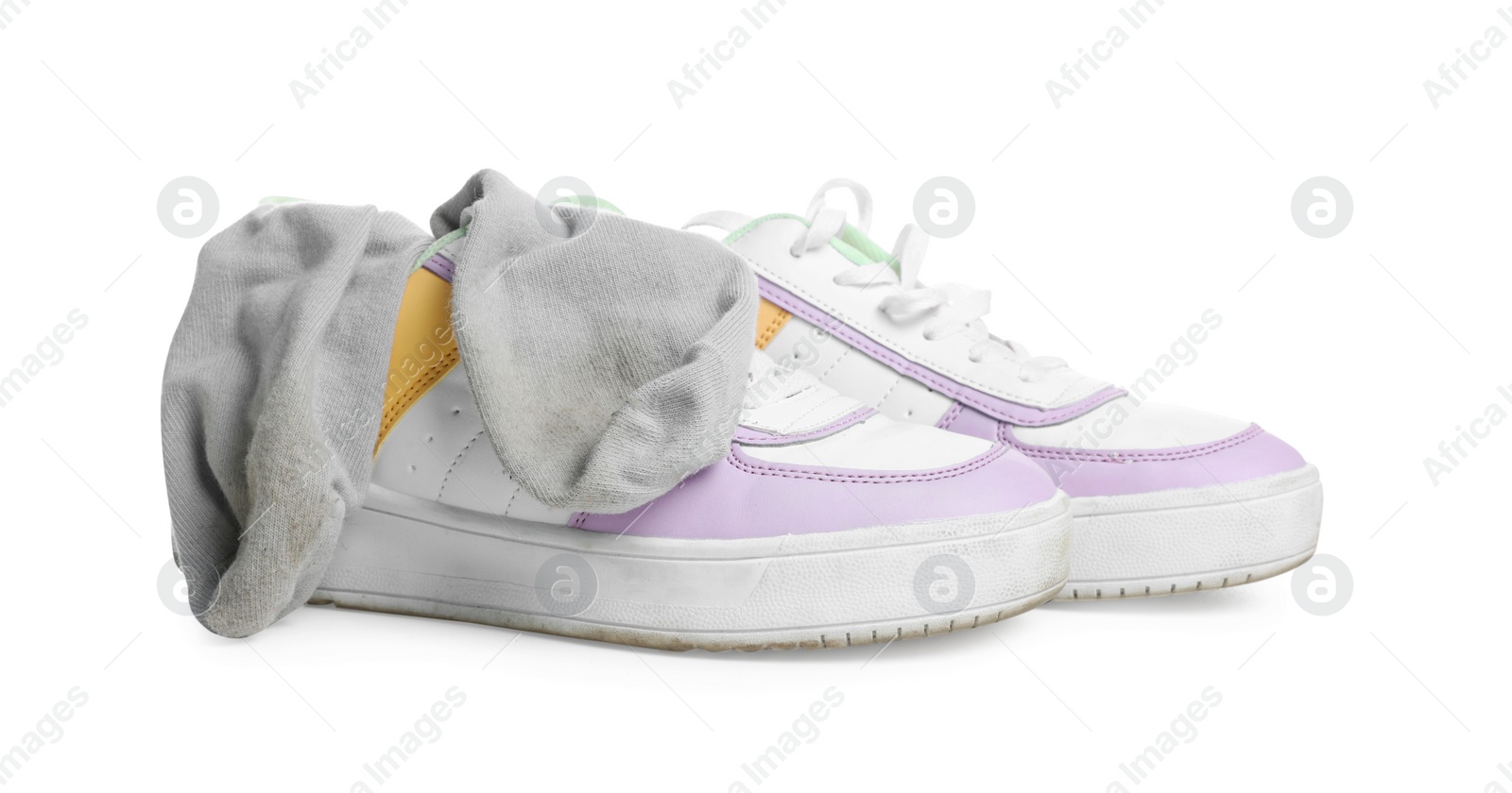 Photo of Dirty socks and sneakers on white background