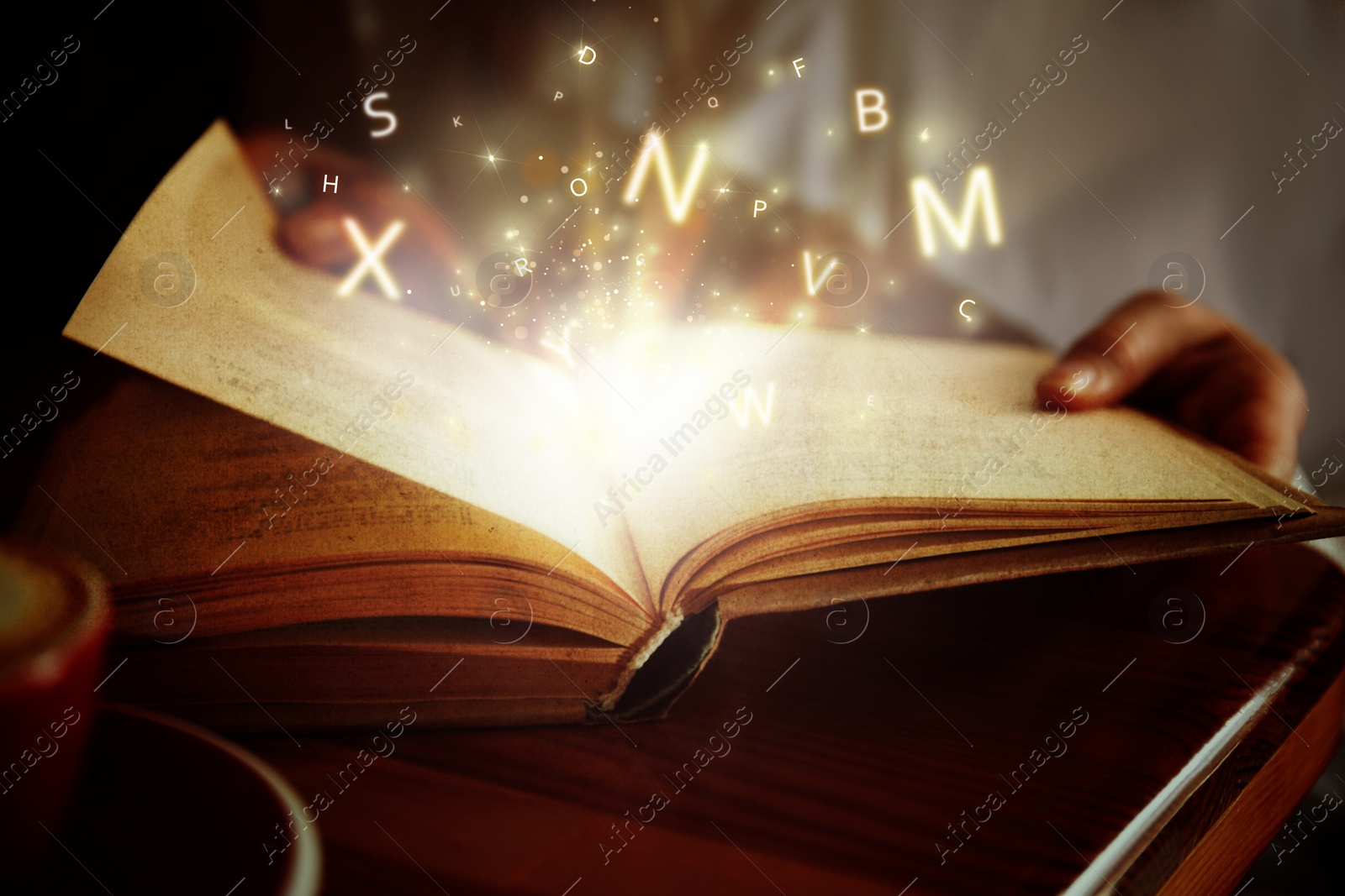 Image of Woman reading shiny magic book with letters flying over it, closeup