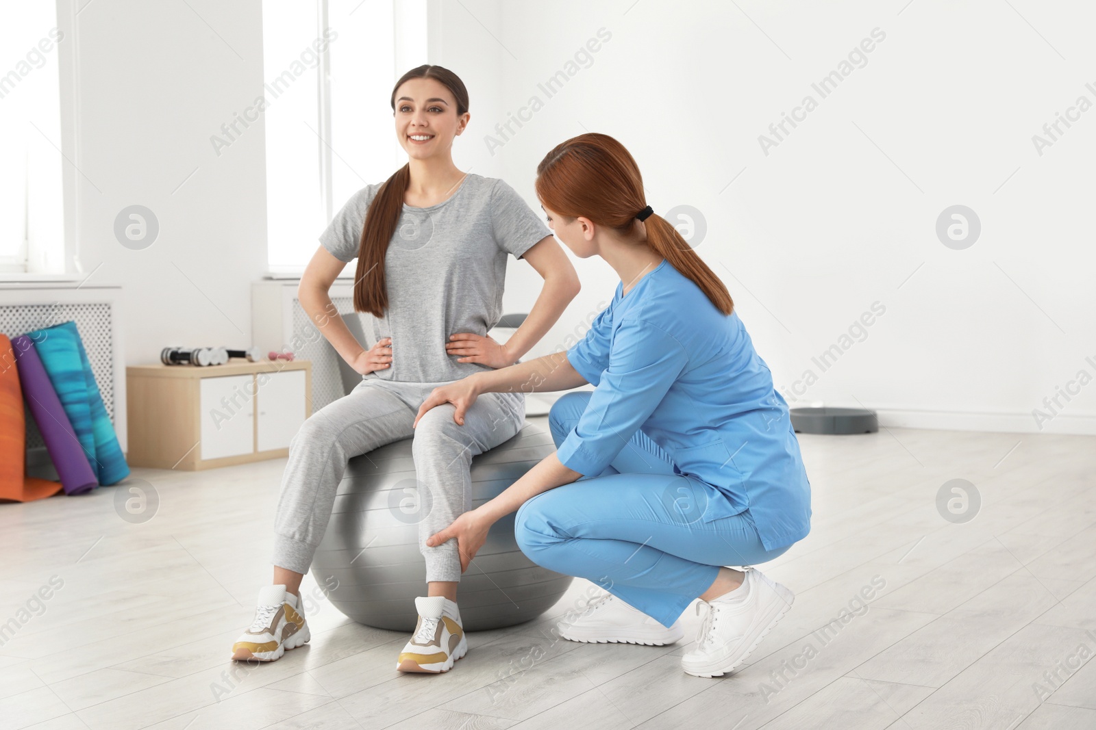 Photo of Professional physiotherapist working with female patient in rehabilitation center