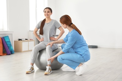 Photo of Professional physiotherapist working with female patient in rehabilitation center