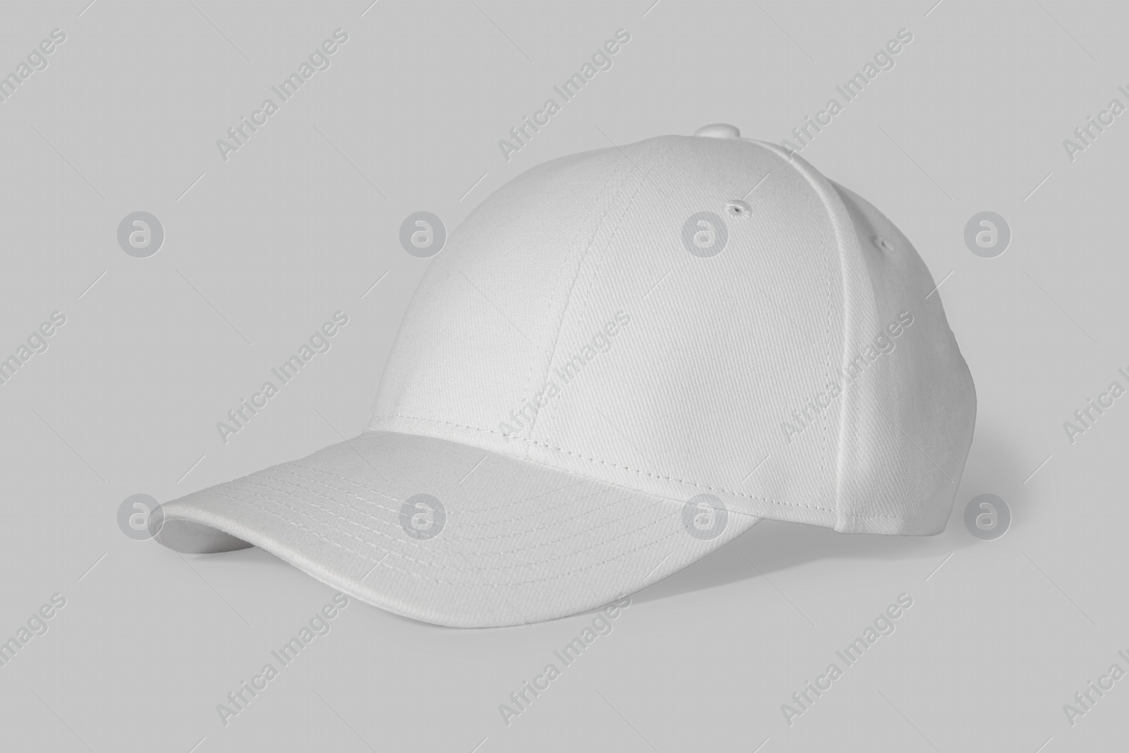 Photo of Stylish white baseball cap on light background