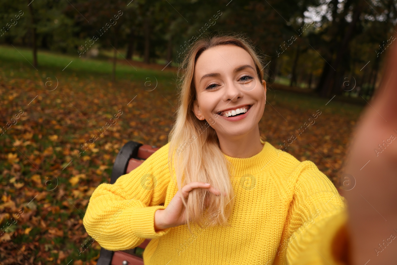 Photo of Portrait of happy woman taking selfie in autumn park