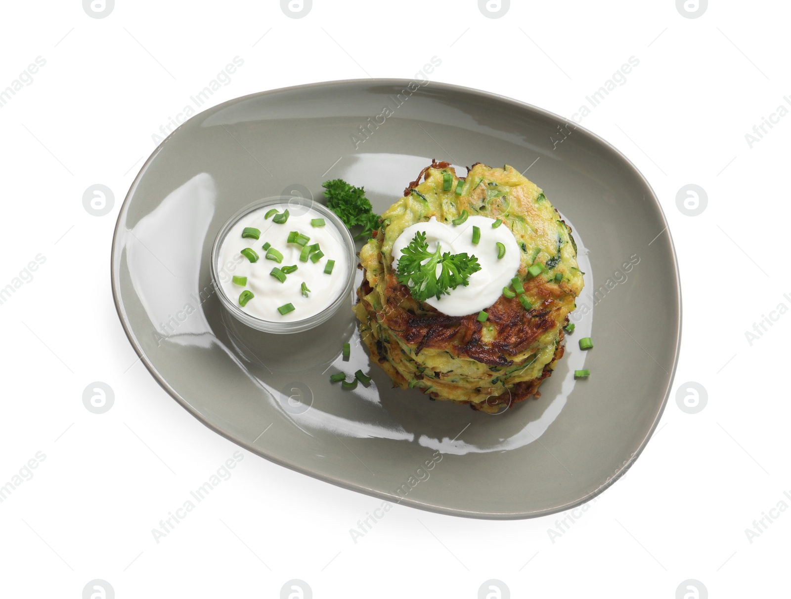 Photo of Delicious zucchini fritters with sour cream on white background, top view