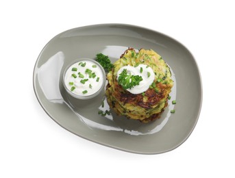 Photo of Delicious zucchini fritters with sour cream on white background, top view