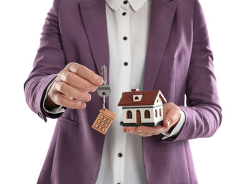 Photo of Real estate agent holding house model and key on white background, closeup