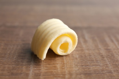 Photo of Fresh butter curl on wooden table