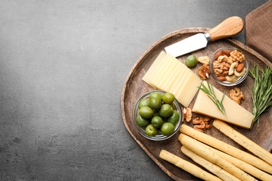 Photo of Snack set with delicious Parmesan cheese on grey table, top view. Space for text