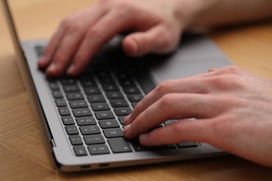 Photo of E-learning. Man using laptop during online lesson at table indoors, closeup