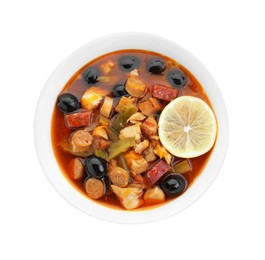 Photo of Meat solyanka soup with sausages, olives and vegetables in bowl isolated on white, top view