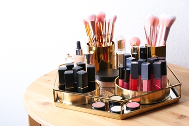 Photo of Set of luxury makeup products and perfume on wooden dressing table