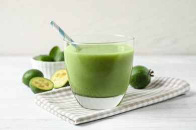 Photo of Fresh feijoa smoothie in glass on white wooden table, closeup