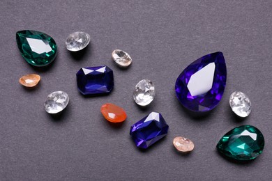 Photo of Different beautiful gemstones for jewelry on grey background, flat lay