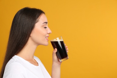 Photo of Beautiful woman with cold kvass on yellow background. Traditional Russian summer drink