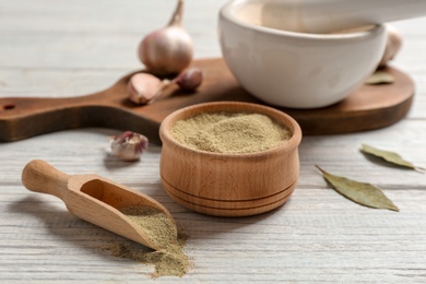 Photo of Composition with powdered pepper in scoop and bowl on wooden table