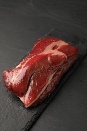 Photo of Piece of raw beef meat on black table