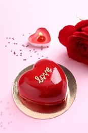 Photo of St. Valentine's Day. Delicious heart shaped cake and rose on light pink background