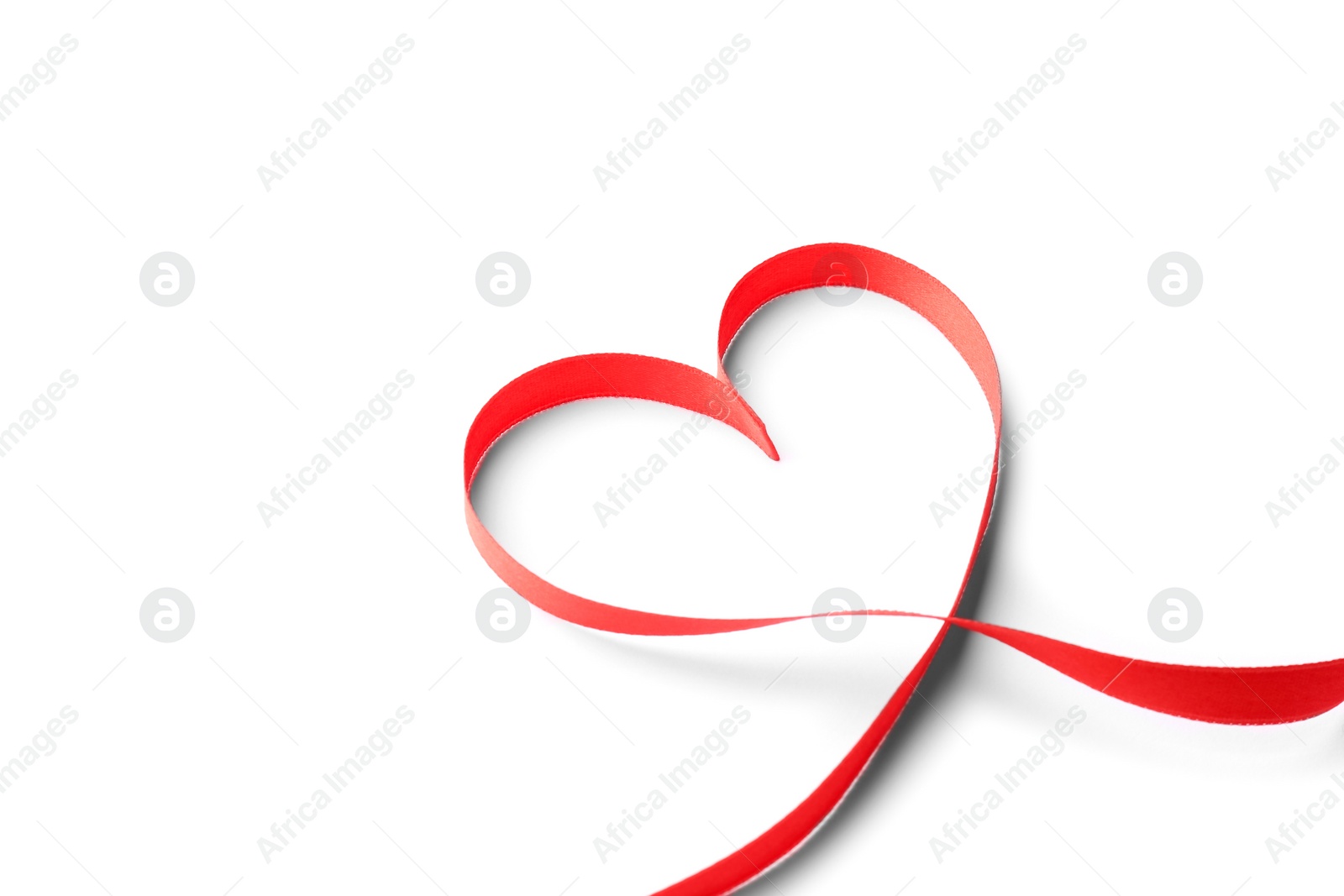 Photo of Heart made of red ribbon on white background. Festive decoration