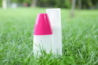 Bottles of insect repellent on green grass