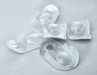 Photo of Packages with contact lenses on light background