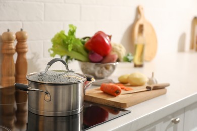 Photo of Pot with delicious bouillon on cooktop in kitchen. Homemade recipe