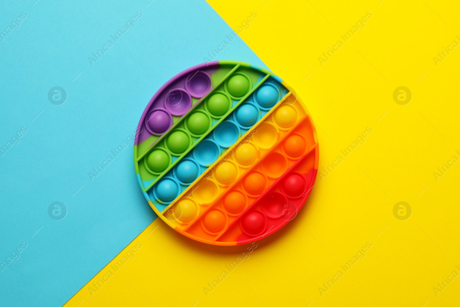 Photo of Rainbow pop it fidget toy on color background, top view