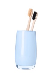 Photo of Bamboo toothbrushes in holder isolated on white