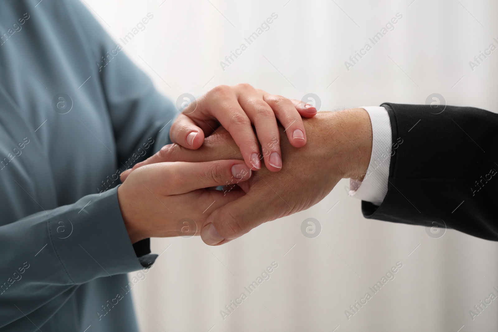 Photo of Trust and deal. Man with woman joining hands on blurred background, closeup