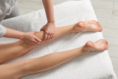 Photo of Woman receiving leg massage in spa salon, closeup