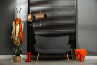 Photo of Hallway interior with sofa, clothes and accessories