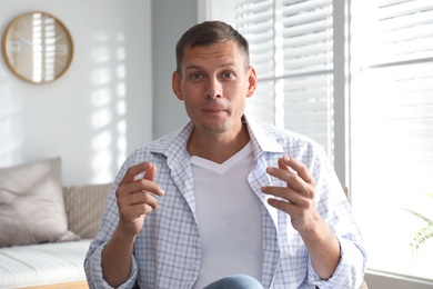 Photo of Man talking to his coworkers through video conference indoors, view from webcam