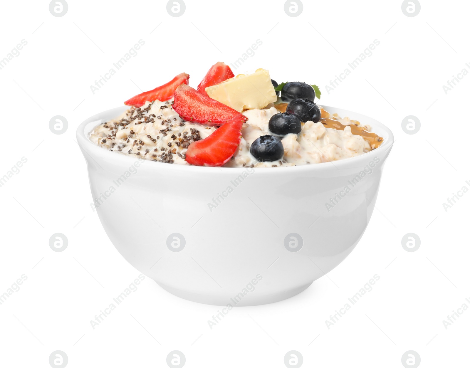Photo of Tasty boiled oatmeal with berries, chia seeds and peanut butter in bowl isolated on white
