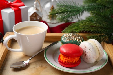Photo of Different decorated Christmas macarons served with coffee on table