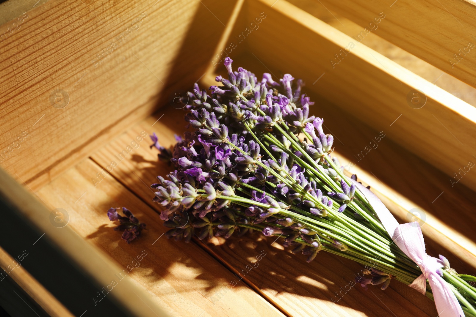 Photo of Beautiful fresh lavender bouquet in wooden crate, closeup