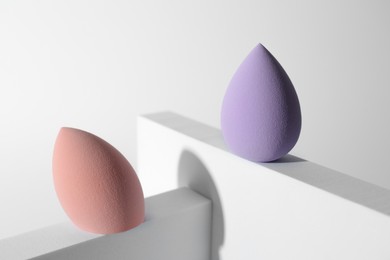 Photo of Stylish presentation of makeup sponges on white background