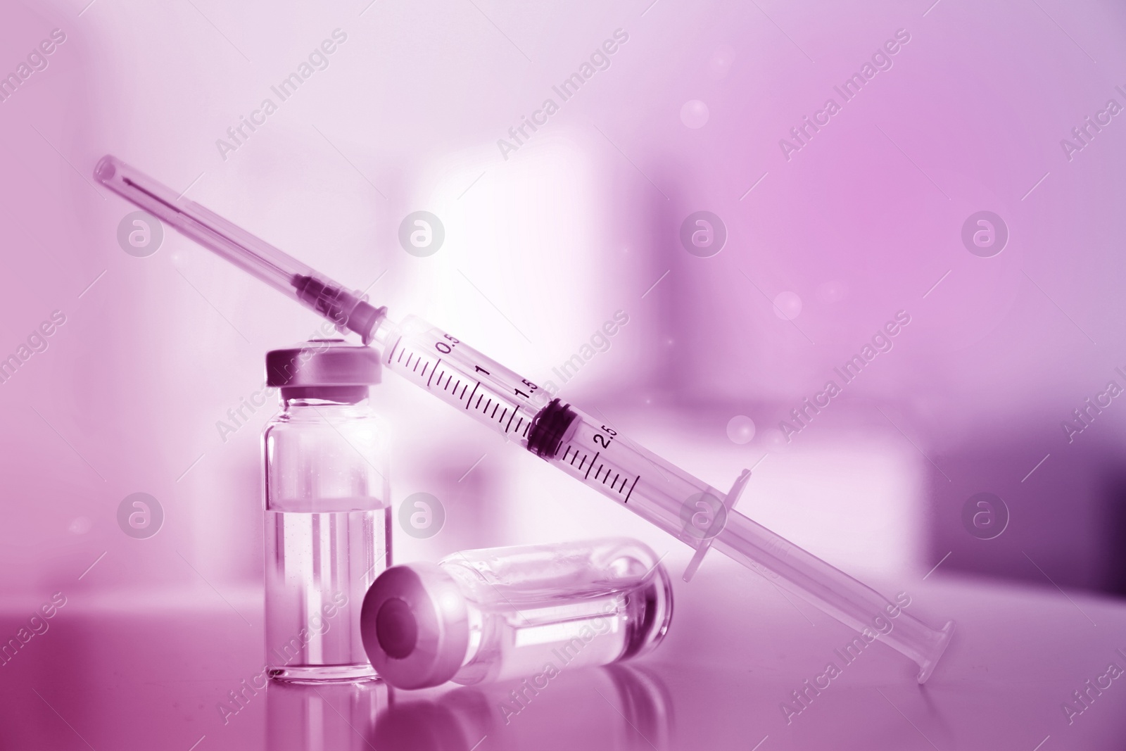 Image of Syringe with vials of medicine on table