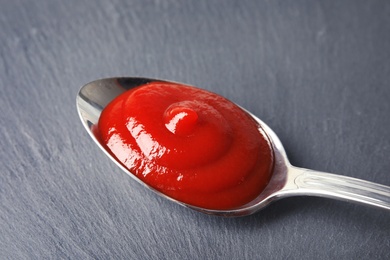 Photo of Homemade tomato sauce in metal spoon on table