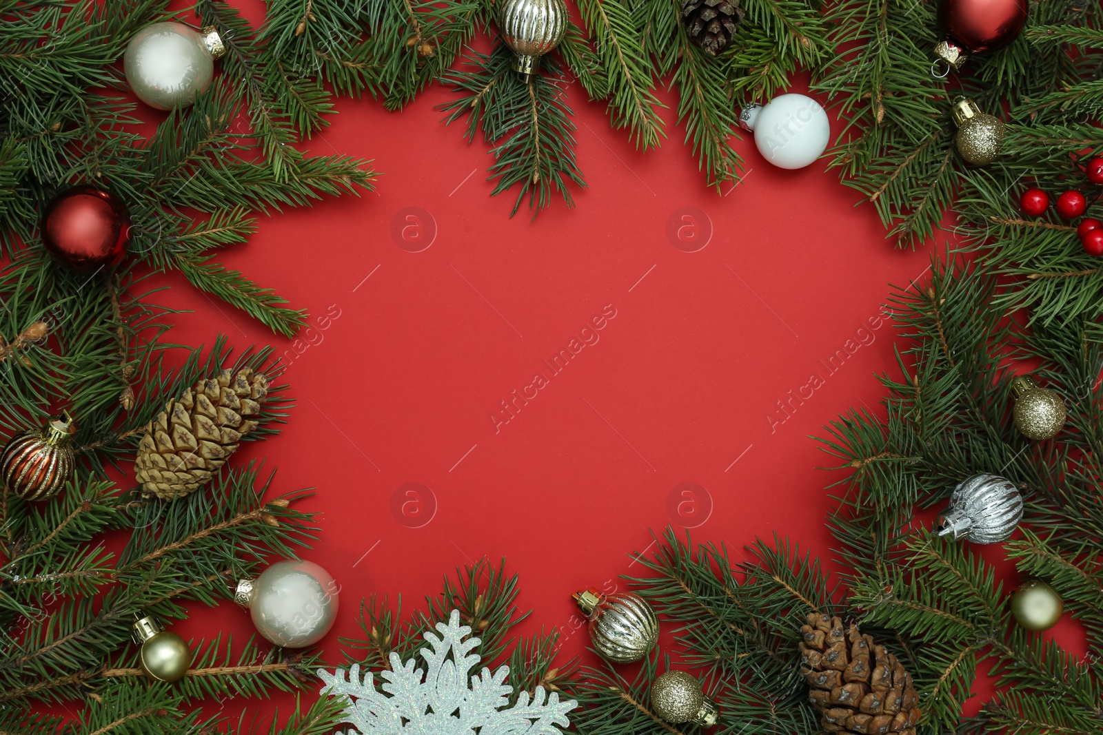 Photo of Frame made of Christmas decor on red background, flat lay. Space for text