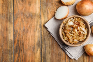 Tasty fried onion on wooden table, flat lay. Space for text