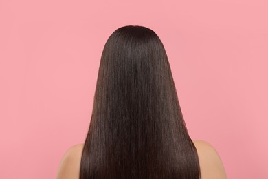 Photo of Woman with healthy hair after treatment on pink background, back view