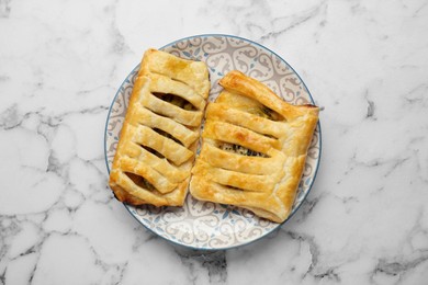 Photo of Fresh tasty puff pastry with kiwi on white marble table, top view