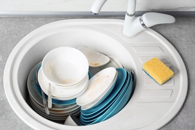 Photo of Messy pile of dirty dishes in sink
