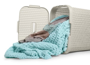 Photo of Overturned laundry basket full of clothes on white background, closeup