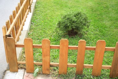 Photo of Small wooden fence on sunny day outdoors