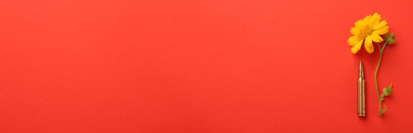 Image of Bullet and beautiful flower on red background, flat lay. Banner design with space for text