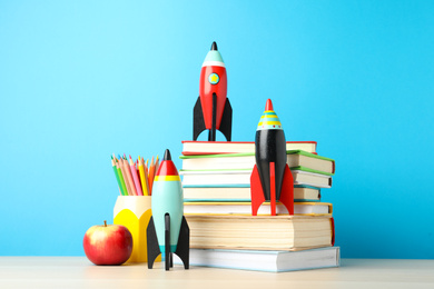 Photo of Bright toy rockets and school supplies on wooden table