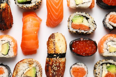 Photo of Different tasty sushi rolls on white background, flat lay