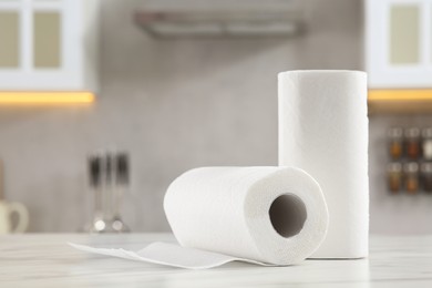 Photo of Rolls of paper towels on white marble table in kitchen. Space for text