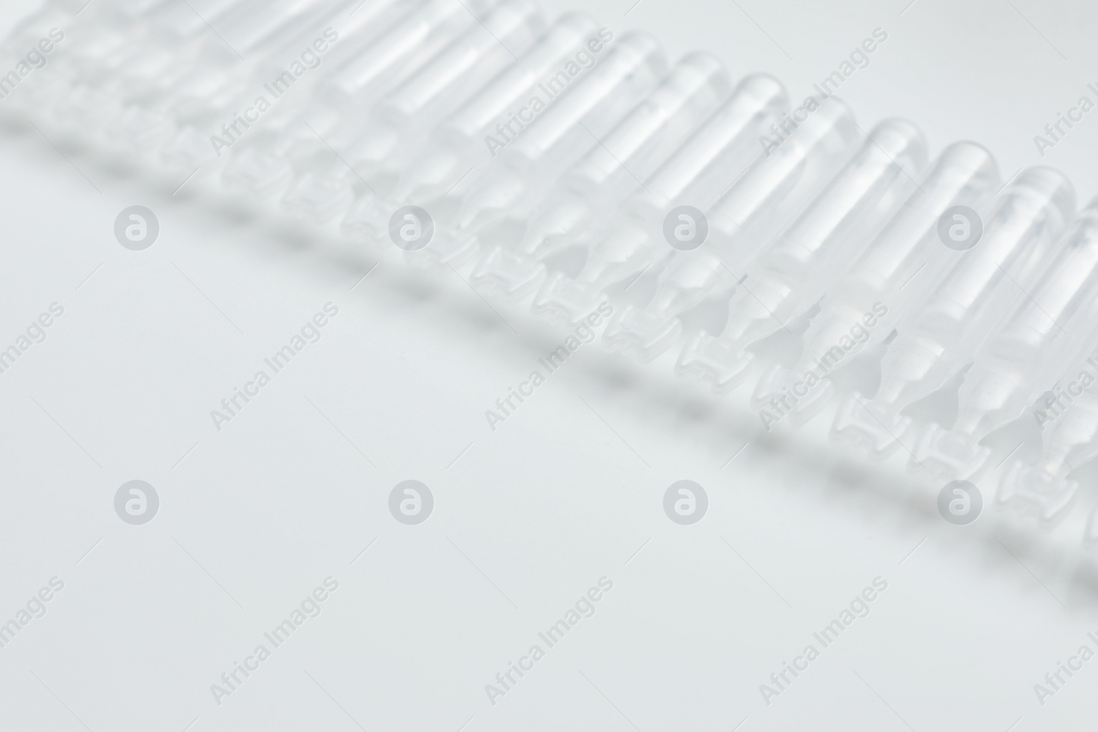 Photo of Single dose ampoules of sterile isotonic sea water solution on white background. Space for text