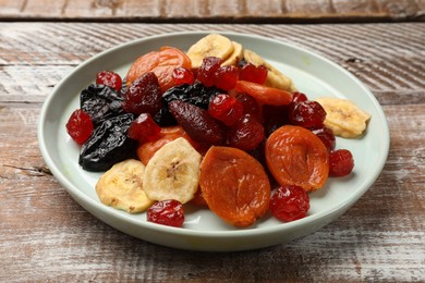 Photo of Mix of delicious dried fruits on wooden table, closeup